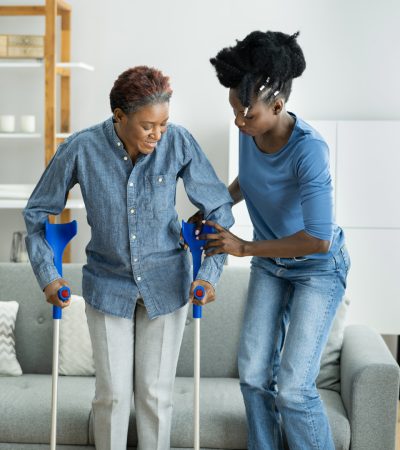 Helping Injured Handicapped African Woman With Crutches